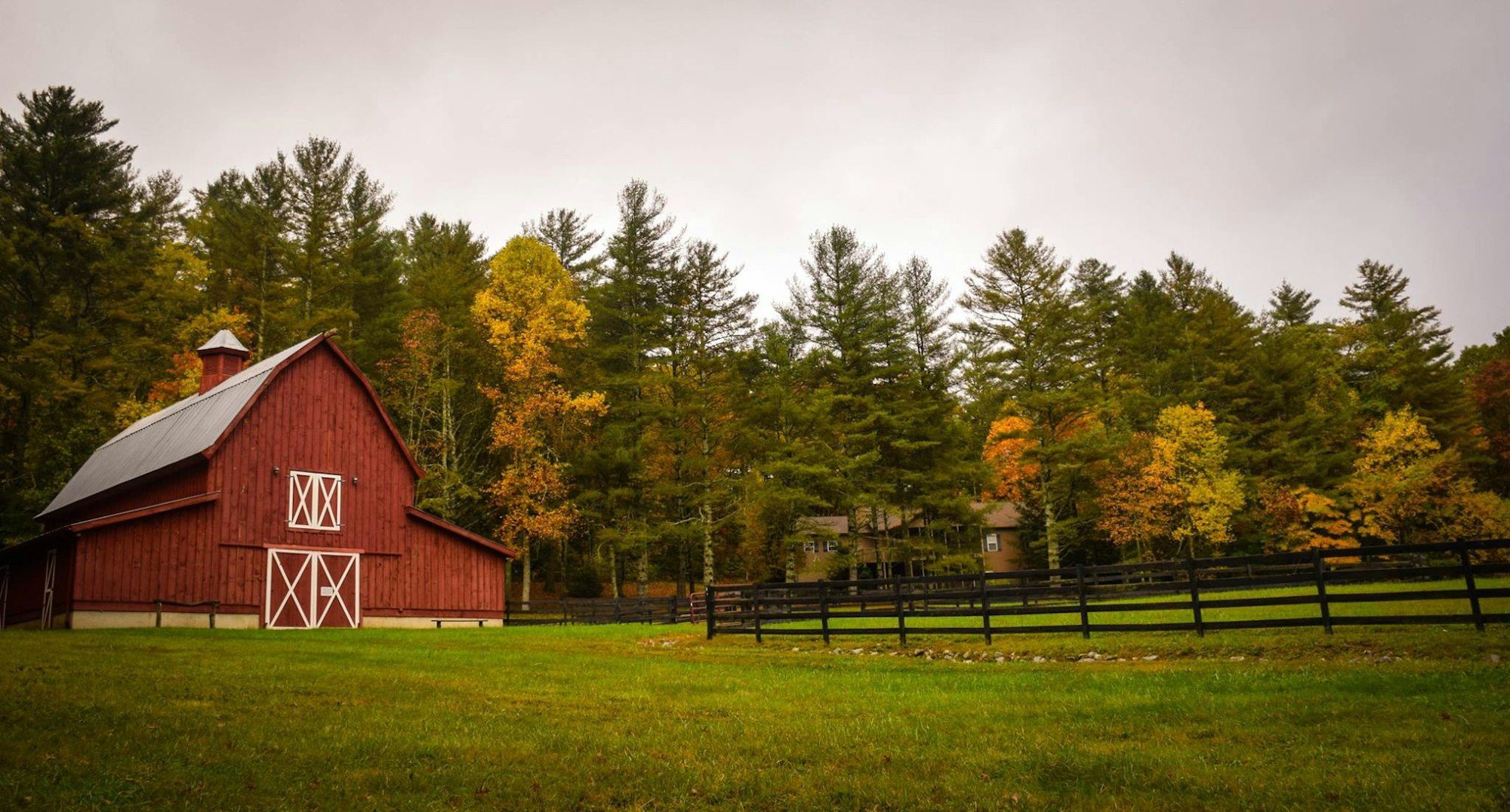 Red barn against autumn woods in the countryside
